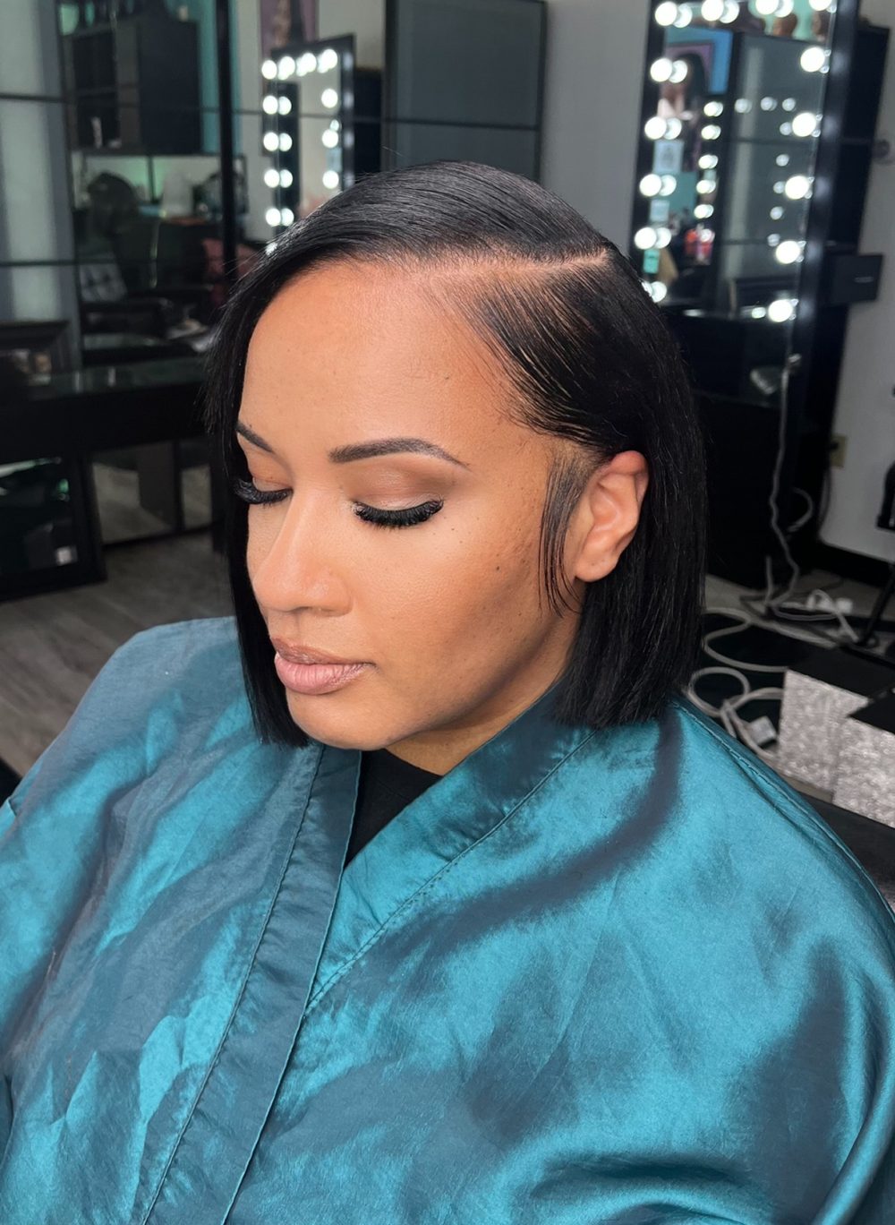 Side profile of a sleek jaw-length bob sew-in with a deep side part and laid edges