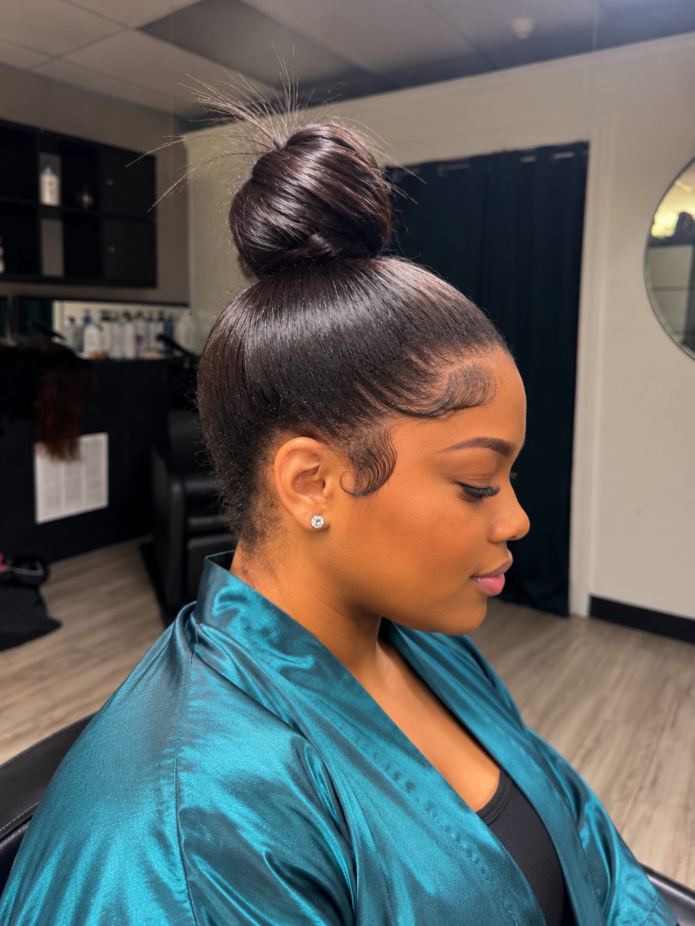 Client sew-in styled into a sleek high bun, shown in profile with laid edges
