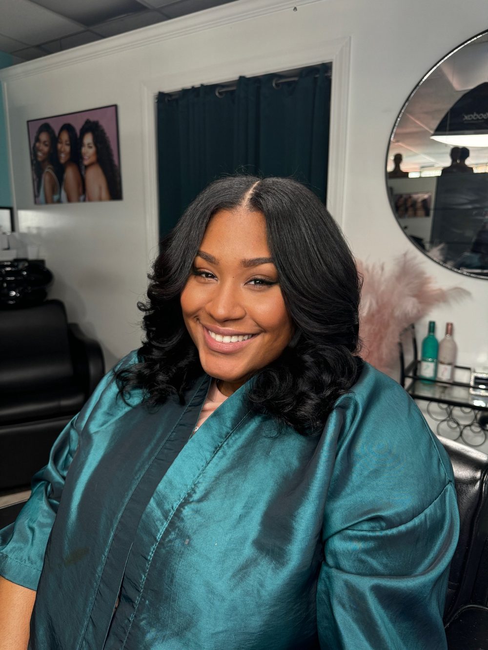 Client sew-in with a center part and soft curled ends at shoulder length